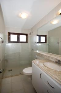 a bathroom with a toilet and a shower and a sink at Casa espetacular em condomínio pé-na-areia, RZ15 in Rio do Fogo