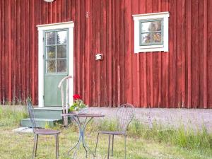dos sillas y una mesa frente a un edificio rojo en 2 person holiday home in N SSJ, en Nässjö