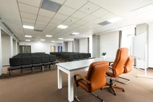 una sala de conferencias con una mesa blanca y sillas en Filo Hotel, en Gheorgheni