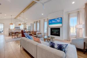a living room with a couch and a fireplace at Luxury new home in desirable resort, beach access, two pools in Port Aransas