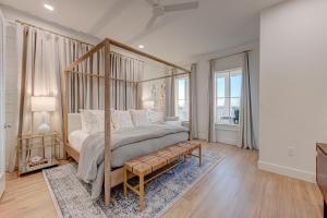 a bedroom with a canopy bed with a bench at Luxury new home in desirable resort, beach access, two pools in Port Aransas