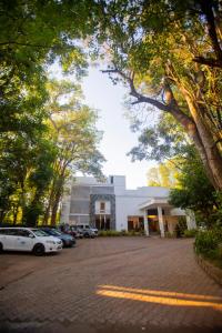 a parking lot with cars parked in front of a building at Hotel Eden Garden in Sigiriya