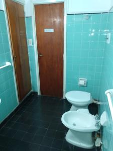 ein Badezimmer mit 2 WCs und einer Holztür in der Unterkunft Villa Coca -Los Jilgueros- in La Bolsa