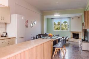 Riposo Studios & Apartments في كافوس: مطبخ وغرفة معيشة مع طاولة وكراسي