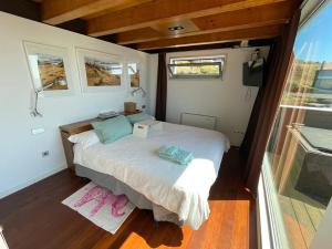 ein Schlafzimmer mit einem Bett in einem winzigen Haus in der Unterkunft Casa en el Atlantico, Villa encima del Mar, A Guarda, Rias Bajas in A Guarda