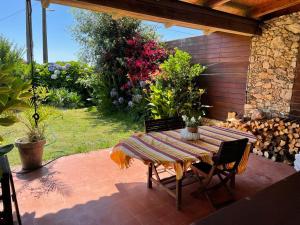 eine Terrasse mit einem Tisch, Stühlen und Blumen in der Unterkunft Casa en el Atlantico, Villa encima del Mar, A Guarda, Rias Bajas in A Guarda