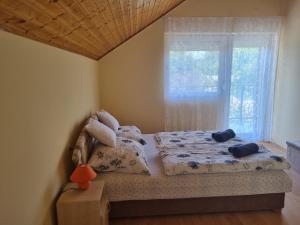 1 dormitorio con cama y ventana en Lilian apartmanház, en Siófok