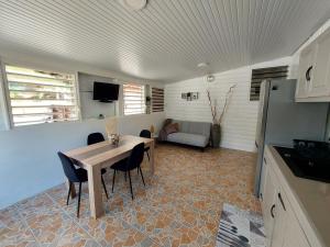 uma cozinha e sala de jantar com mesa e cadeiras em Location LUKYNIA em Goyave