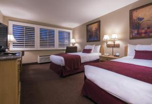a hotel room with two beds and a television at Grand Vista Hotel in Simi Valley