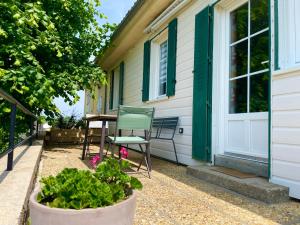 una casa con una silla y una mesa en el porche en Caporizon-La Marote-Gite calme tout neuf, en Lanobre