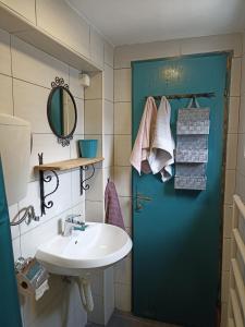 ein Badezimmer mit einer blauen Tür und einem Waschbecken in der Unterkunft 19th century stone house on the seashore in Radovići