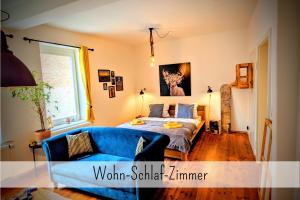 a bedroom with a bed and a blue couch at Uhlpartment - Romantisches Apartment im Zentrum in Uelzen