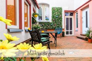 un patio con mesa, sillas y flores en Uhlpartment - Romantisches Apartment im Zentrum, en Uelzen