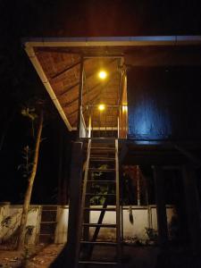 a house with a staircase leading up to a light at night at Anandam Woods - A Heritage single Room for couple-small family in Vaikom
