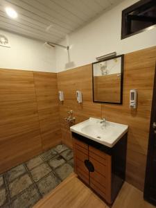 a bathroom with a sink and a mirror at Anandam Woods - A Heritage single Room for couple-small family in Vaikom
