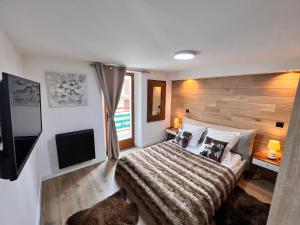 a bedroom with a bed and a flat screen tv at Chalet Millou Beuil in Beuil
