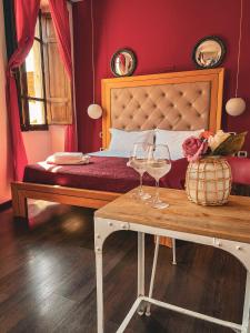 um quarto com uma cama com uma mesa e copos de vinho em Chambres Du Monde em Cagliari