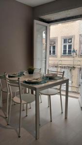 a dining table and chairs in a room with a window at APOSENTUS - St Francisco Apartment in Porto