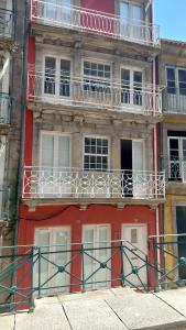 a red building with white balconies on top of it at APOSENTUS - St Francisco Apartment in Porto