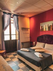 a bedroom with a large bed with red walls at Chambres Du Monde in Cagliari