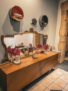 um toucador com um espelho e pratos na parede em Chambres Du Monde em Cagliari