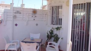 een kamer met witte stoelen, een tafel en een deur bij Charming 2-Bed Apartment in Almunecar in Almuñécar