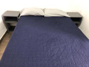 Milpa AltaにあるCasa de huéspedesの紫色のベッドカバーと枕が備わるベッド1台