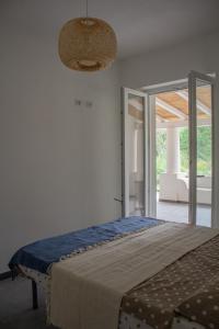una camera con un letto e una porta in vetro di Teia Holiday Apartments a Vulcano