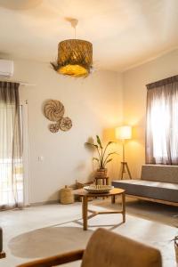Dohos Skiathos Suites في مدينة سكياثوس: غرفة معيشة مع أريكة وطاولة