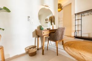 a desk with a mirror and a chair in a room at Dohos Skiathos Suites in Skiathos +39 photos