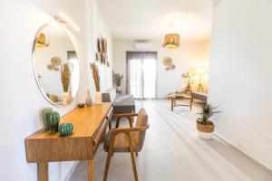 een woonkamer met een tafel en een spiegel bij Dohos Skiathos Suites in Skiathos-stad