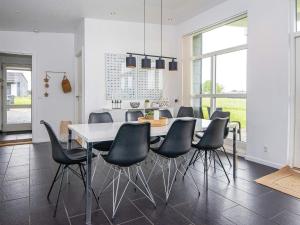 uma sala de jantar com uma mesa branca e cadeiras pretas em Holiday home Haderslev L em Haderslev