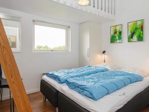 um quarto com uma cama grande e lençóis azuis em Holiday home Haderslev L em Haderslev