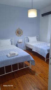 a bedroom with two beds and a mirror on the wall at Madeline house in Kavála