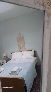 a bedroom with a white bed with a mirror at Madeline house in Kavála