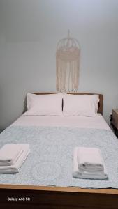 a bed with two white towels on top of it at Madeline house in Kavála