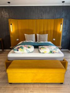 a large yellow bed with two pillows on it at Sofia Apartment & Zimmer in Sillweg