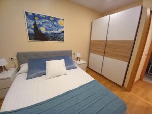1 dormitorio con 1 cama y una pintura en la pared en Apartamento Aurora en Villaviciosa