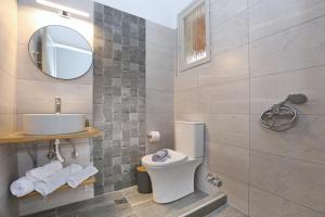 a bathroom with a toilet and a sink and a mirror at Skopelos Panos Studios in Stafylos +45 photos