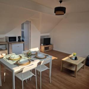 een woonkamer met een witte tafel en stoelen bij appartement à 20 minutes de Paris St Lazare et Stade de France in Sannois