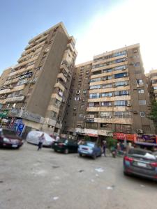 ein Parkplatz mit Autos vor hohen Gebäuden in der Unterkunft Star House City Stars in Kairo