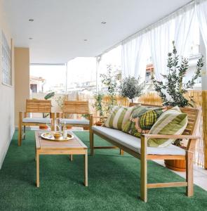 uma sala de estar com dois bancos e uma mesa em Flowery Penthouse in city centre of Thessaloniki em Tessalónica