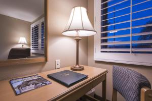 a desk with a lamp and a book on it at Grand Vista Hotel in Simi Valley