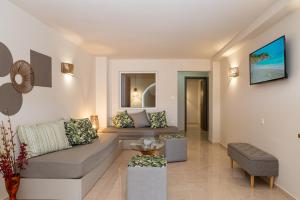 a living room with a couch and a table at Buganvilla-Sea front villas in Agia Pelagia