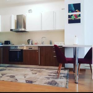 cocina con mesa, 2 sillas y fregadero en Spacious One Bedroom Apartment en Esenyurt