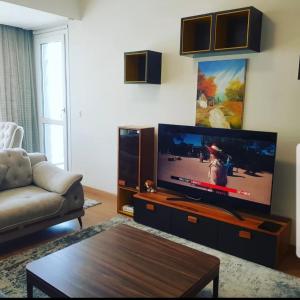 sala de estar con TV de pantalla plana grande en Spacious One Bedroom Apartment en Esenyurt