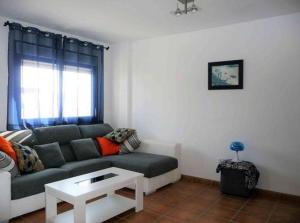 una sala de estar con un sofá y una mesa en Dúplex casa agua, en San José