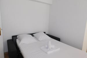 a white bed with two white towels on it at Cosy air-conditioned T2 "New California" with parking in Antibes