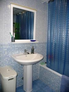 baño con lavabo y cortina de ducha azul en Dúplex casa agua, en San José 12 fotos más