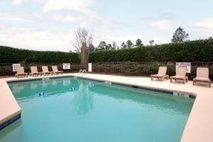una piscina con sillas y una piscina en Days Inn by Wyndham Seneca-Clemson, en Seneca